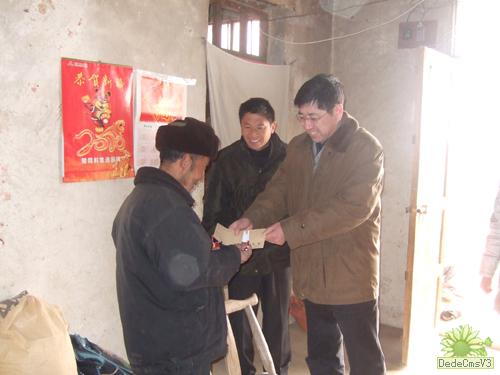 图为河南省测绘局副局长王进福正在走访慰问困难村民