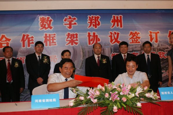 河南省测绘局副局长禄丰年与郑州市政府副市长张建慧代表双方签约