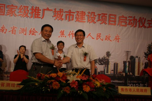 河南省测绘局代表禄丰年与焦作市人民政府代表胡小平共贺签约成功