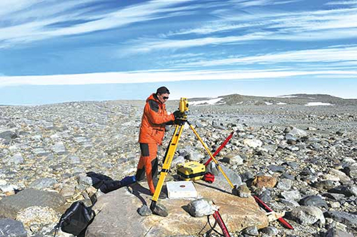 图为颜小平正在进行维多利亚地新建站1：500地形图测绘。