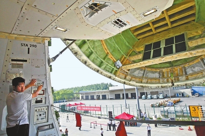 6月27日,机场工作人员正打开波音747-8F全货机的机鼻舱门。(记者 王铮 摄)