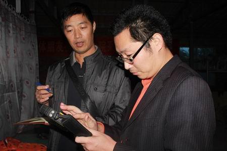 普查人员手握&ldquo;调绘宝&rdquo;向记者讲解使用方法