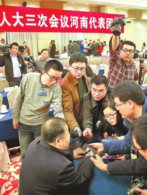 在河南团开放日,凌解放代表被记者团团围住。(记者 杜小伟 摄)