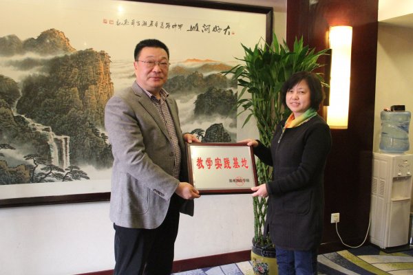 图为李骏元副校长向我院代表冯梅副院长授牌