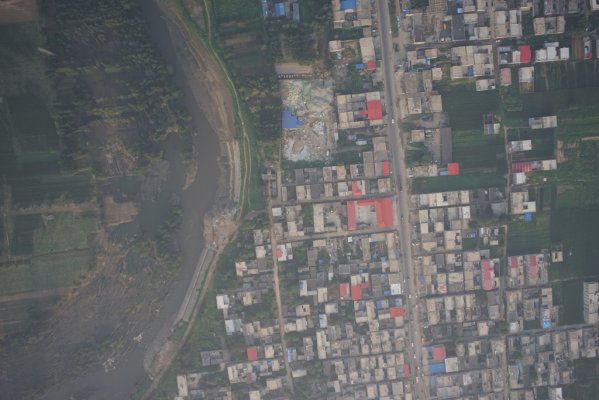 灾区航拍照片（图中清晰可见河道冲倒的树木）