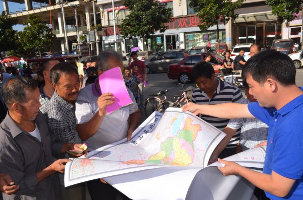 刘国朝副县长在为群众发放地图